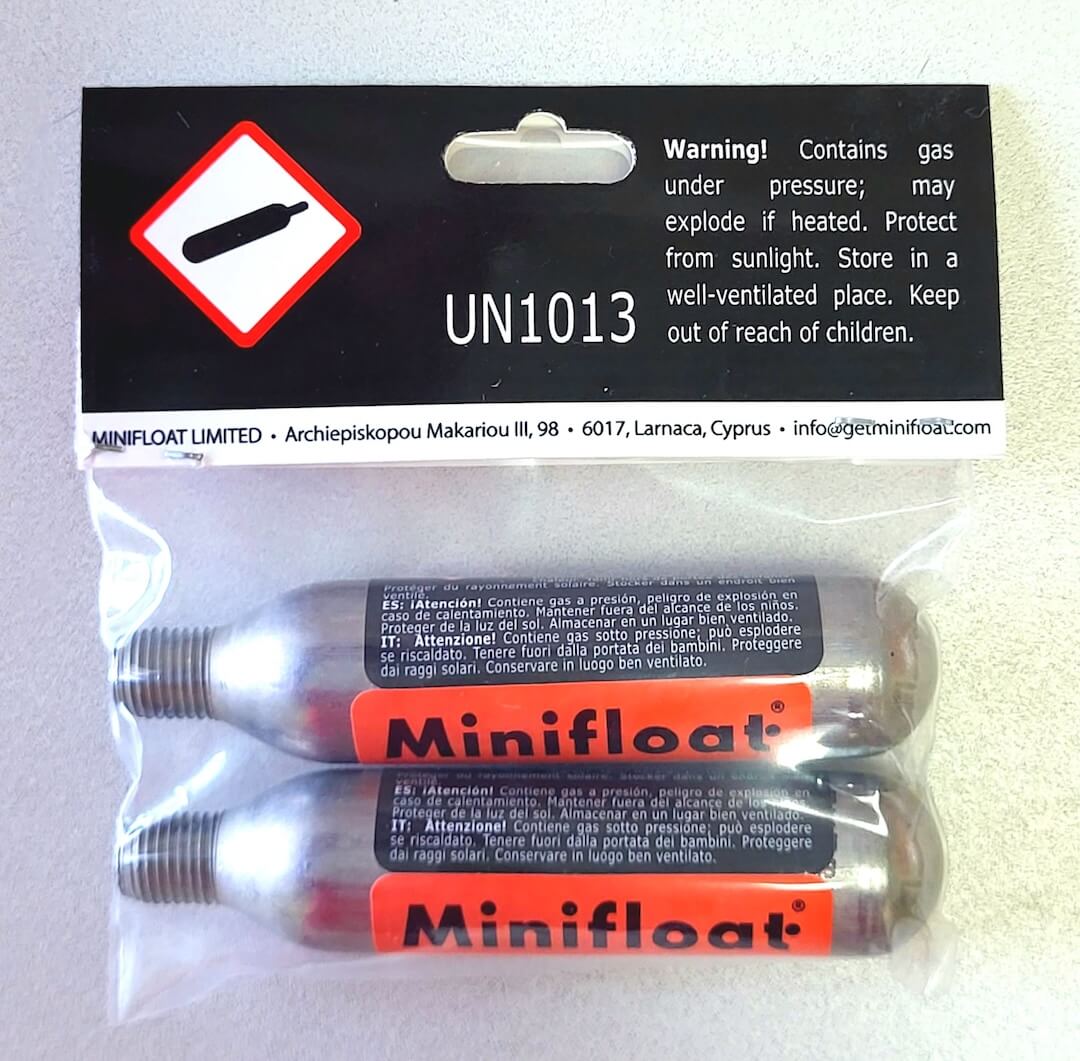 Minifloat CO2 refills in packaging with warning label on a light gray background
